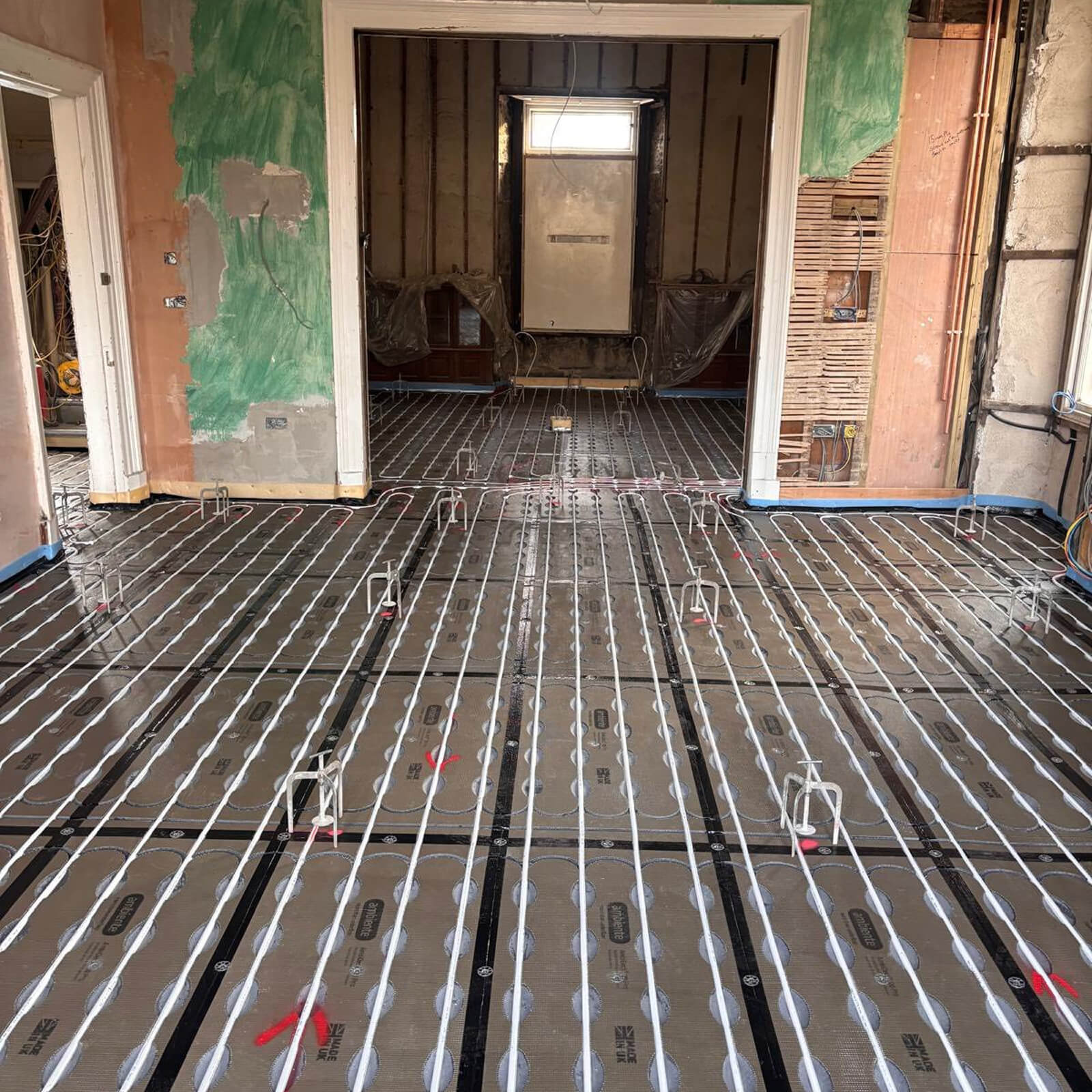 Underfloor heating pipework professionally prepared and secured before screed application in a residential setting